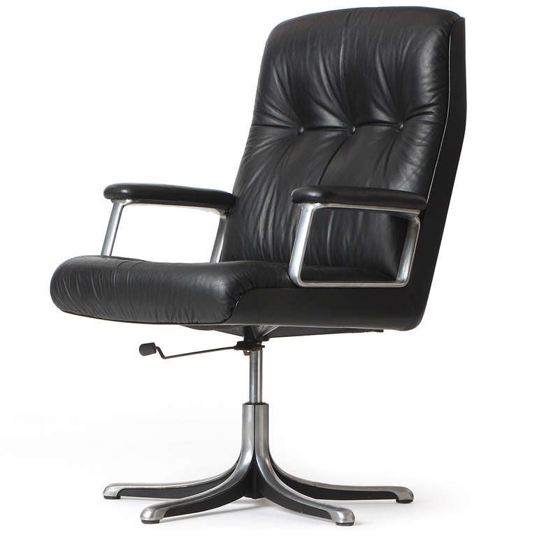 A handsome and stately swiveling and adjustable desk chair having a five-pronged base supporting a generously proportioned button-tufted leather seat.