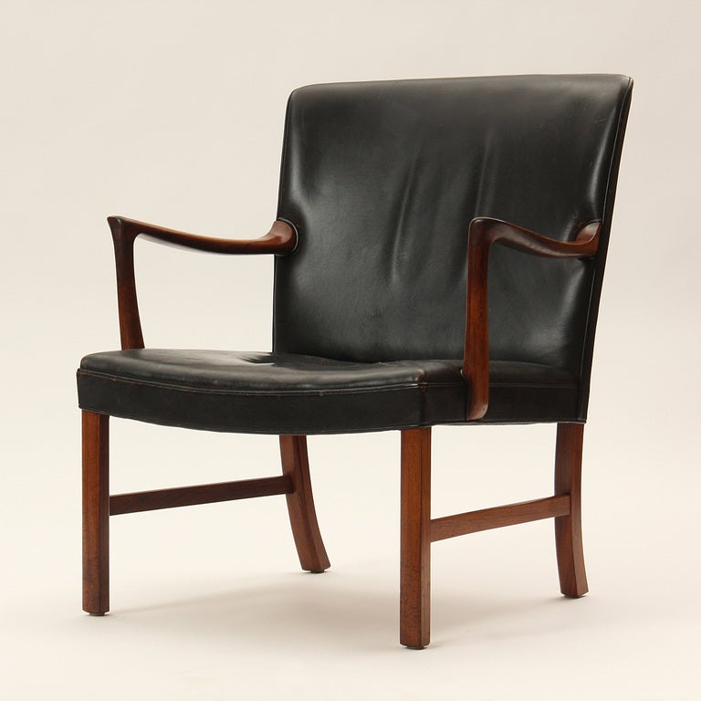 A rosewood armchair or lounge chair with the original black leather upholstery.