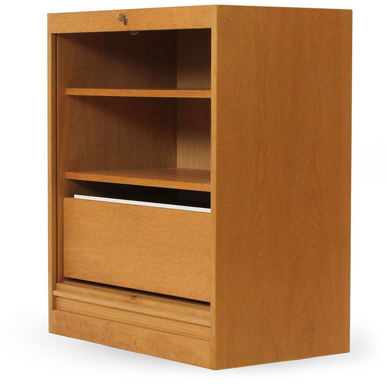 An uncommon and beautifully simple storage cabinet in white oak having a finely slatted tambour front that conceals adjustable shelves and file storage.