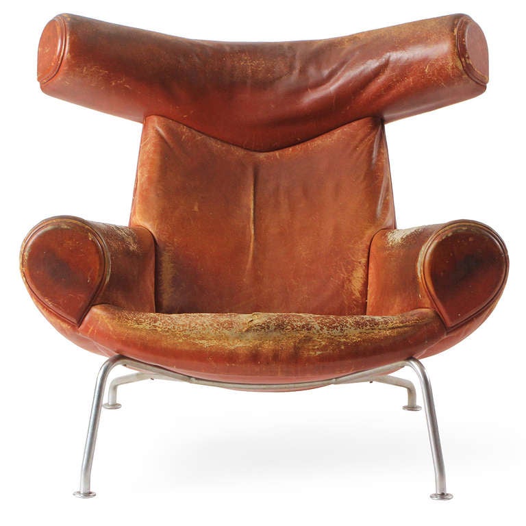 An early limited production Ox lounge chair with a large sculptural head rest and exquisitely comfortable seat all upholstered in leather with a rich patina atop chromed steel tubular legs. 
The Ox chair was born from Wegner's fascination with the