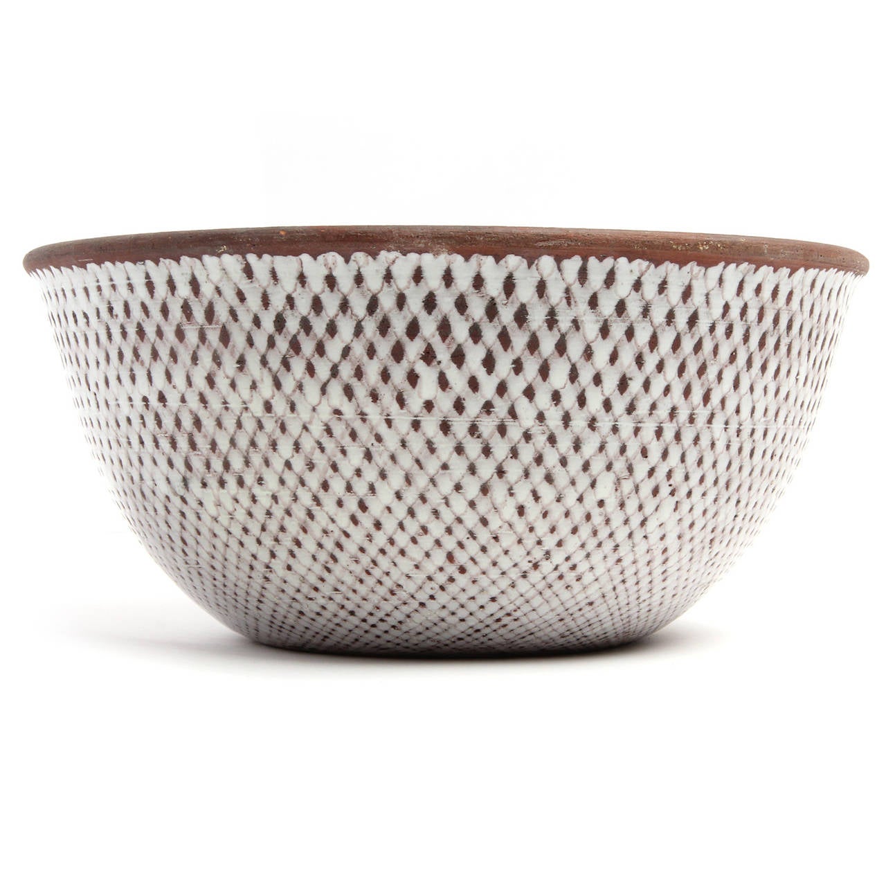 A well scaled and masterfully executed hand thrown ceramic bowl having a matte black interior glaze and an expressive cream-toned diamond grid-patterned outer glaze that contrasts with the naked mocha clay of the bowl peering through underneath.