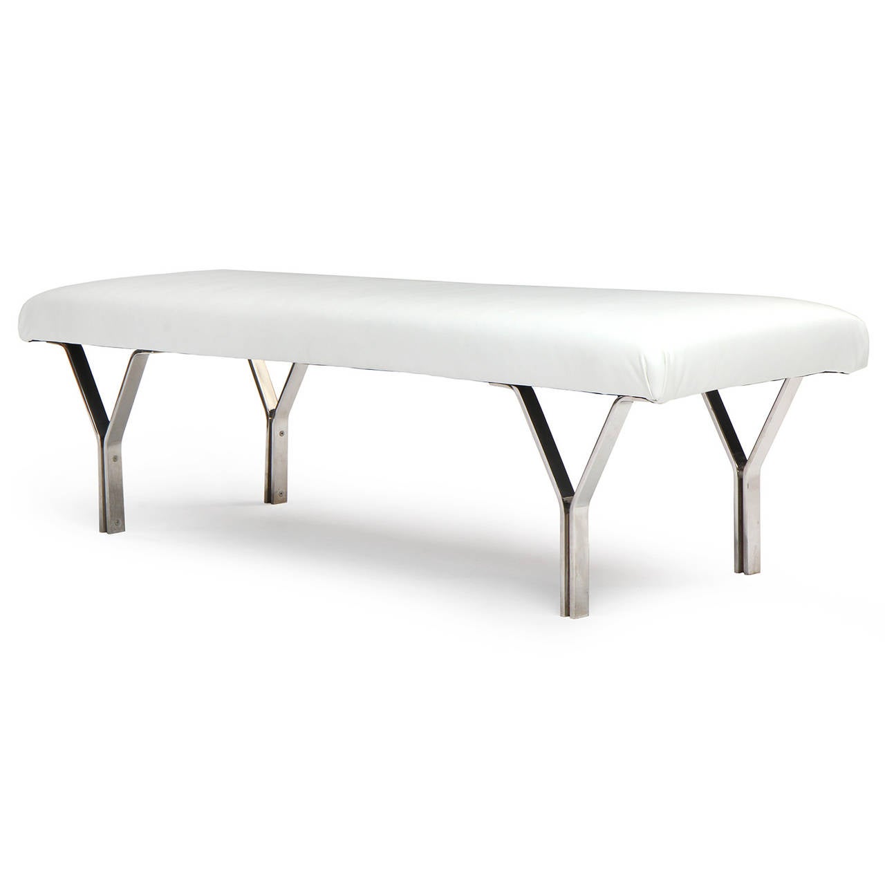 A spare and striking Mid-Century Modern bench having four architectural chromed steel Y-form legs supporting a floating rectangular white leather upholstered seat. Made in USA, circa 1960s.