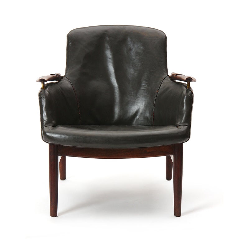 A lounge chair with original black leather and exposed frame with 