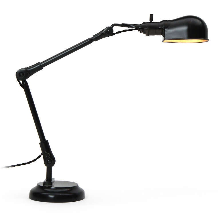 An adjustable desk lamp in patinated steel having a pivoting egg shaped shade attached to a slender stem that rises from a weighted and stepped base.