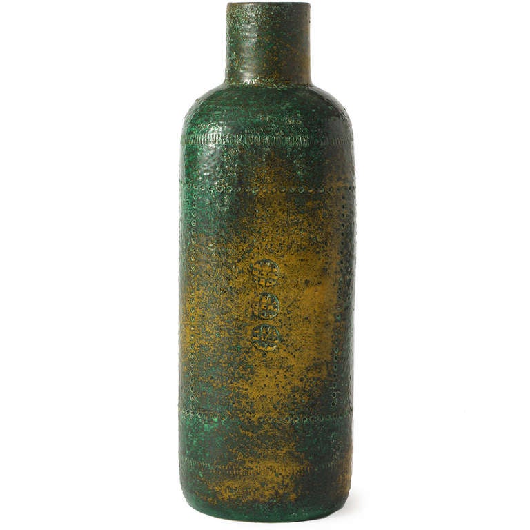 An expressive hand-thrown studio ceramic tall cylindrical vase having sloping shoulders and flattened sides and covered in a rich and complex umber-to-brackish green glaze.