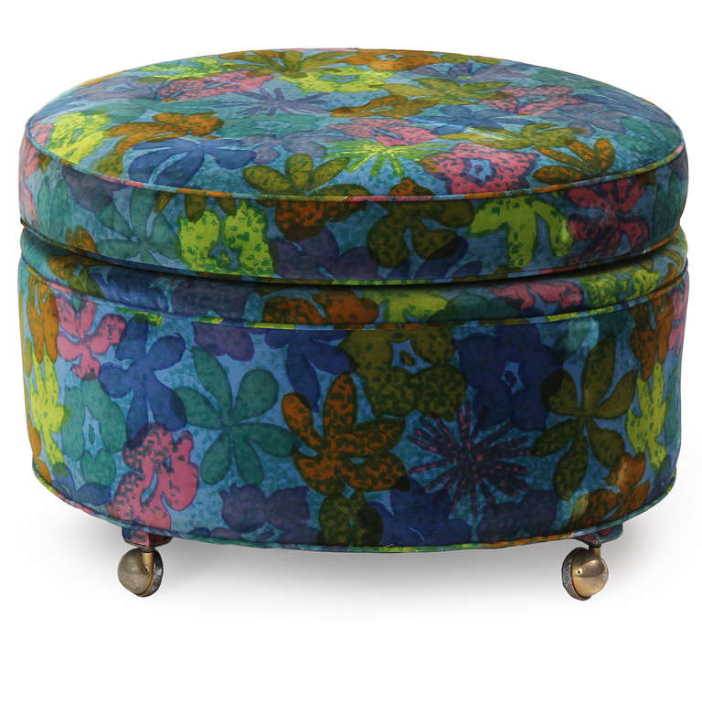 A well-scaled button-tufted round pouf on casters covered in an exuberant floral fabric by Jack Lenor Larsen.