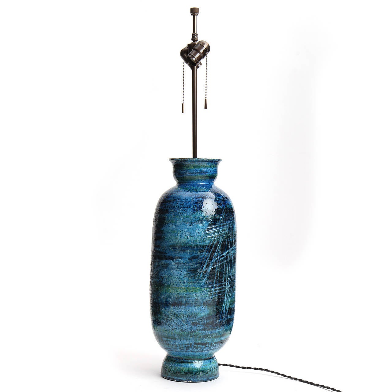 An expressive, well-scaled and beautifully proportioned unique ceramic table lamp having a footed baluster form, incised decoration and covered in a rich variegated deep blue glaze with undertones of green and black.