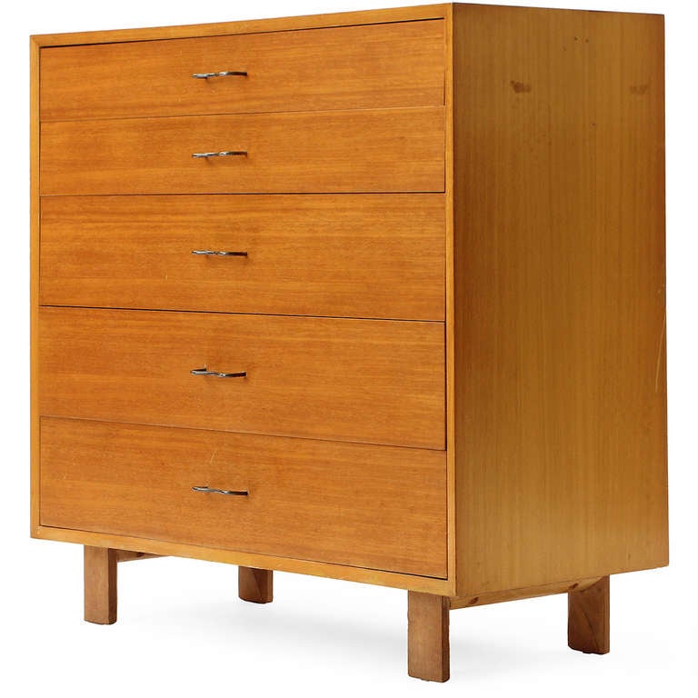 An elegantly simple rectilinear chest of drawers in bleached ash with gracefully curved steel pulls, which floats on squared low wooden legs.