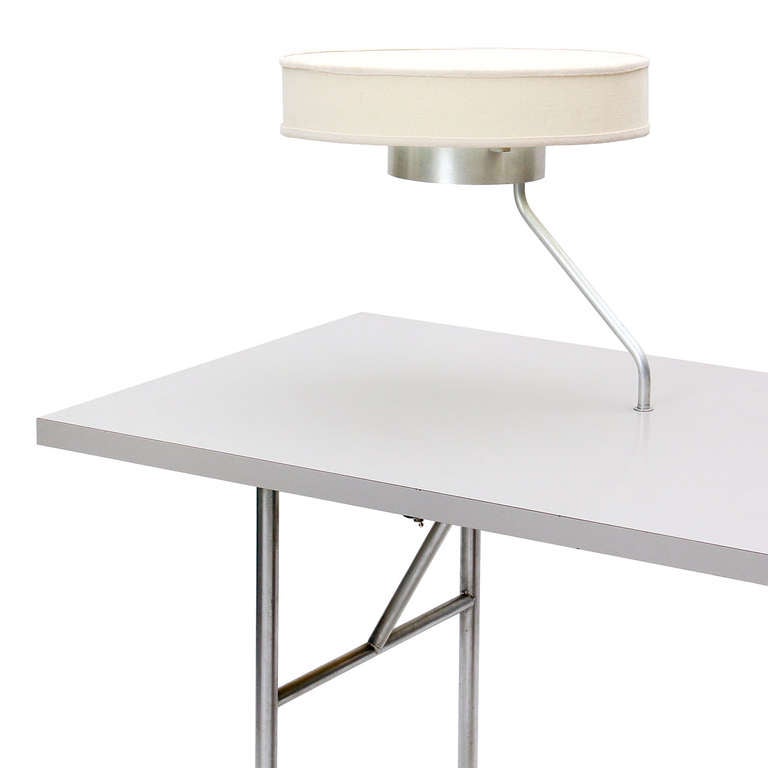 A single pedestal writing desk by George Nelson for Herman Miller with a built-in pivoting lamp. Lamp is 18
