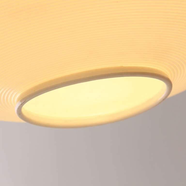 A Rotaflex spun plastic teardrop-shaped wall fixture designed by Yasha Heifetz. The lamp emits a soft diffused light and features brass counterweight to adjust shade drop. The lamp also swivels on its wall mount. Made by Yasha Heifetz, circa 1950s.