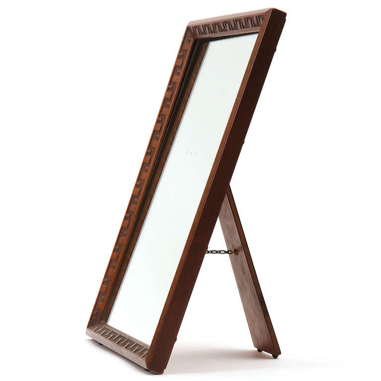 A freestanding mahogany mirror with a 