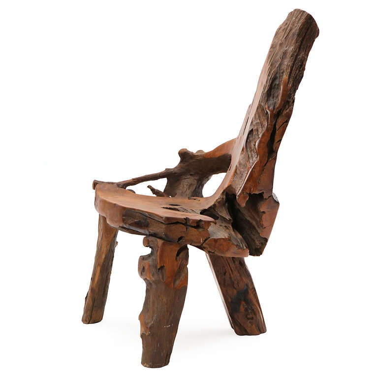 An expressive and rustic chair of generous scale carved from a single massive piece of hardwood.