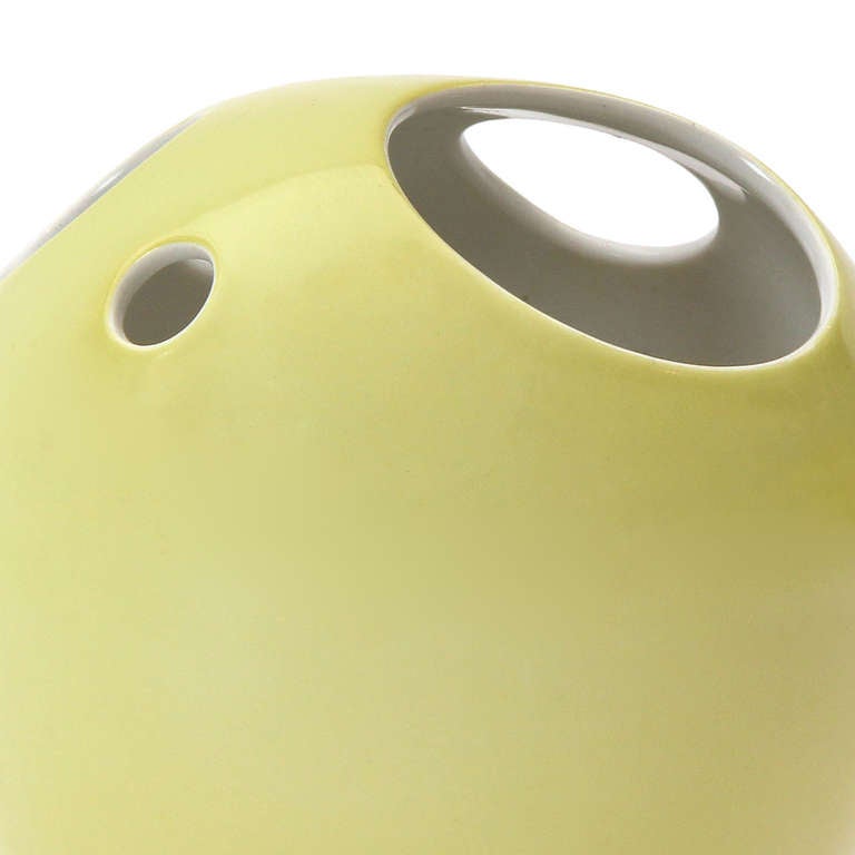 A beautiful glazed porcelain vase or flower frog having a spherical shape perforated with circles of varying sizes.