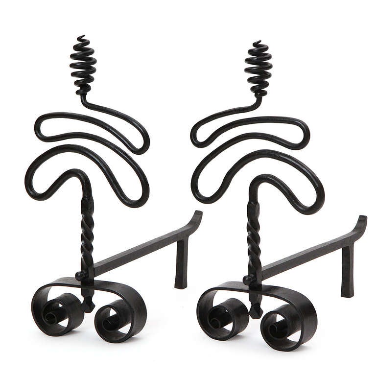 A pair of wrought iron andirons having scrolled feet and highly expressive looping, twisting and spiraling uprights.