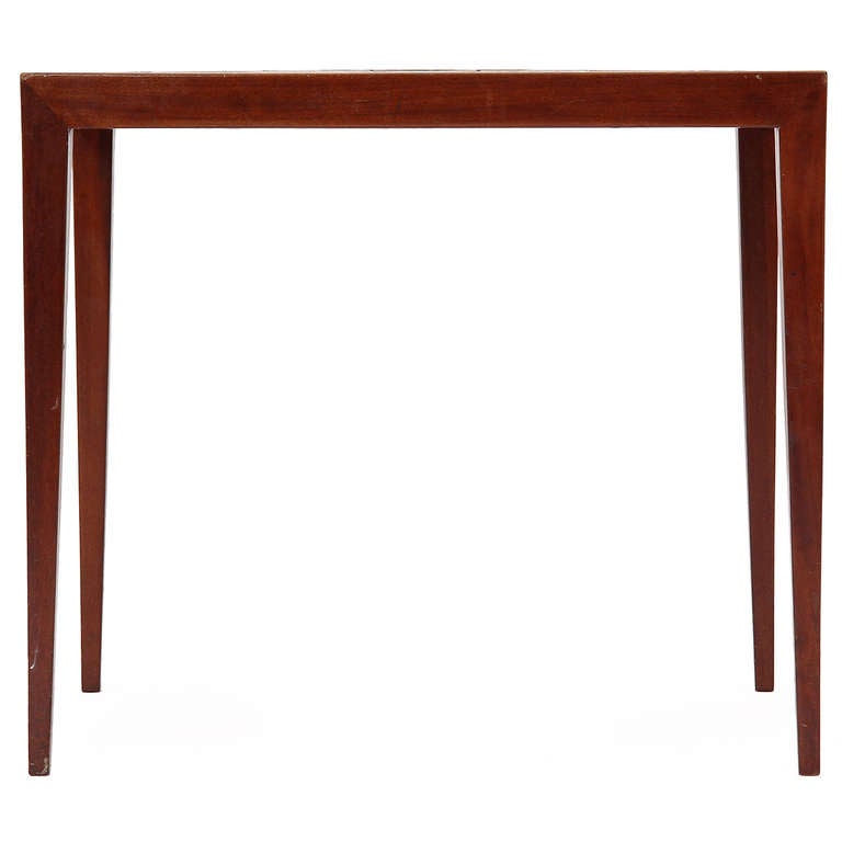 A refined occasional table in mahogany having subtly tapering legs and a top inlaid with expressive Royal Copenhagen porcelain tiles designed by Nils Thorsen.