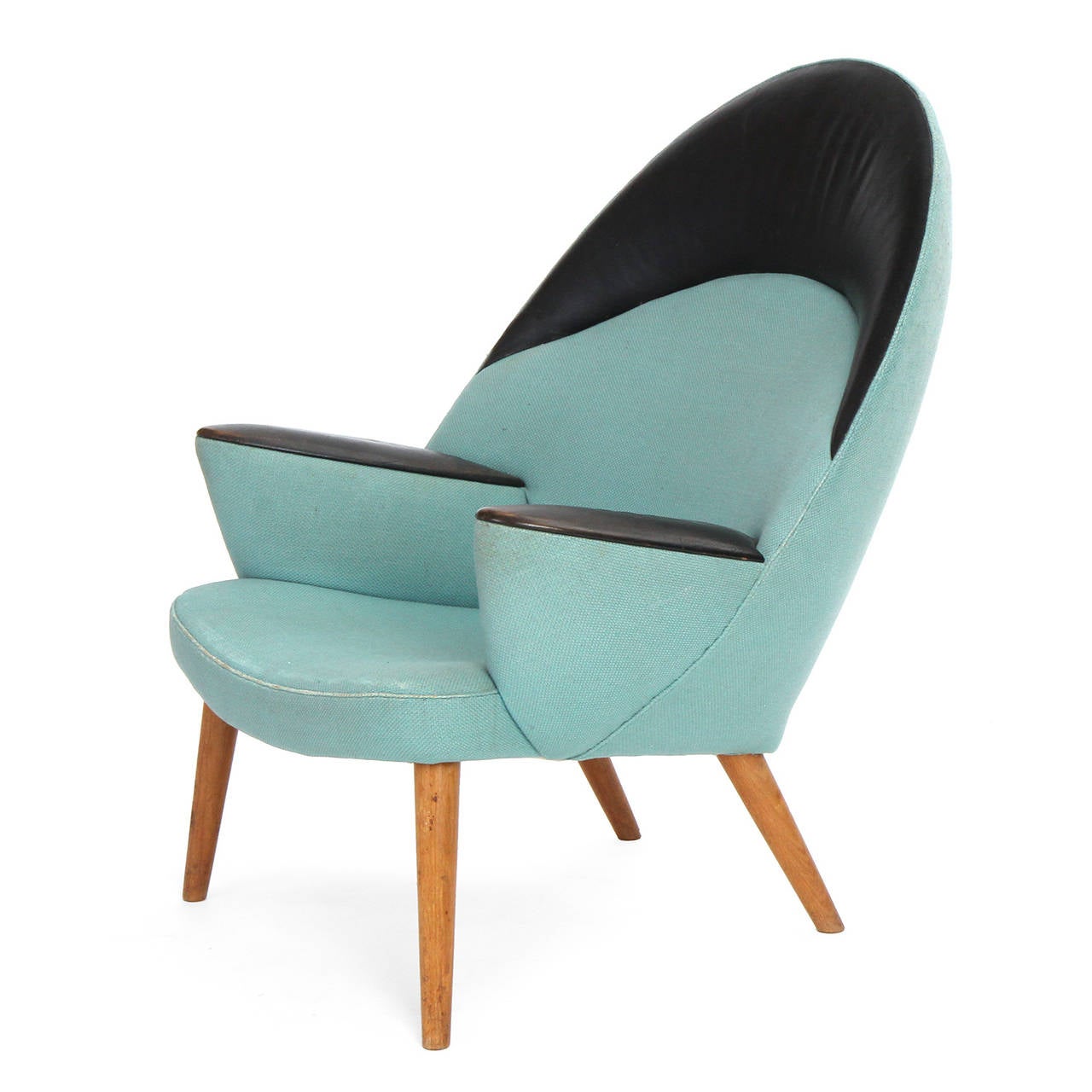 An exquisite and extraordinarily rare and early upholstered peacock armchair having a sculptural and generously proportioned body of rounded and arched form, upholstered in an elegantly resolved combination of fabric and leather and floating on