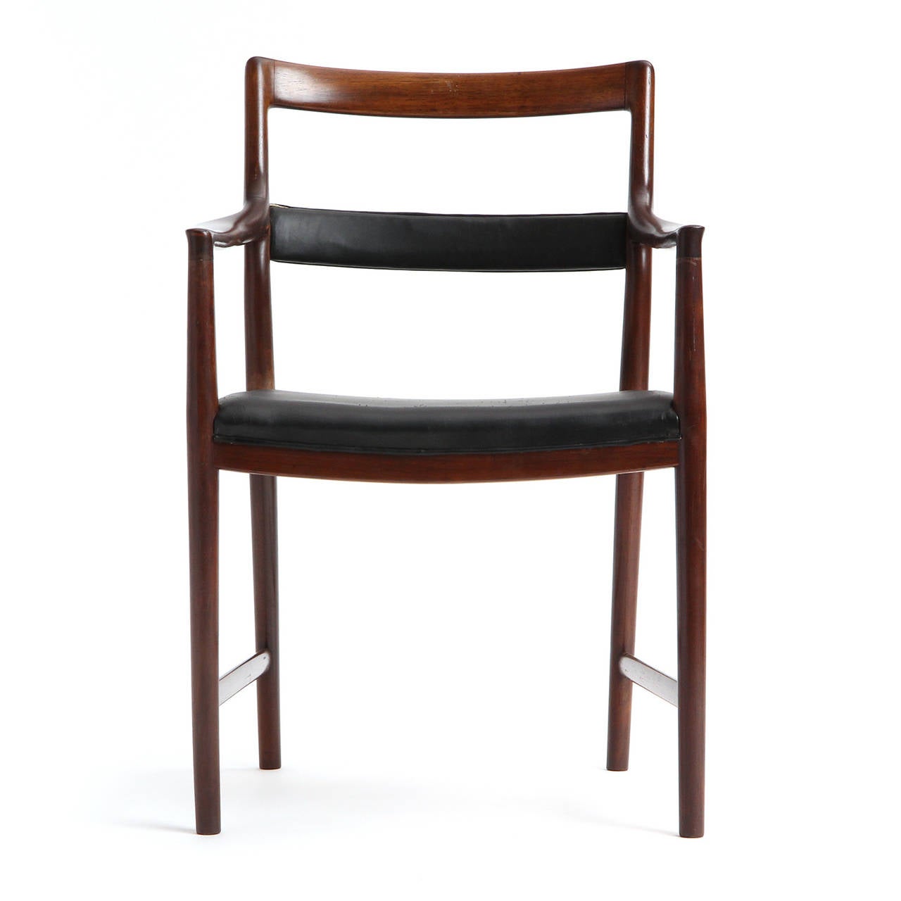 A fine, sculptural and spare group of ladder back dining chairs having luminous Brazilian rosewood frames with black leather seats and expressive leather-wrapped center slats.