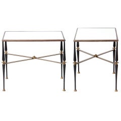 A pair of bronze end tables with delicate legs and cross stretch