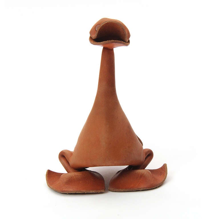 A single piece of natural leather cut, folded and riveted into the shape of a duck.