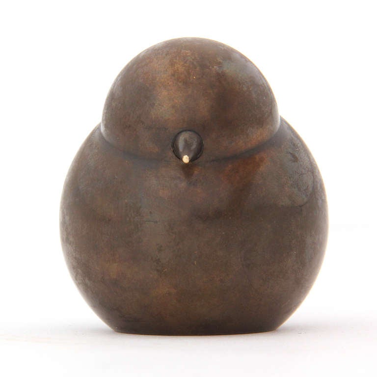A small bronze pen holder in the shape of a roosting bird.