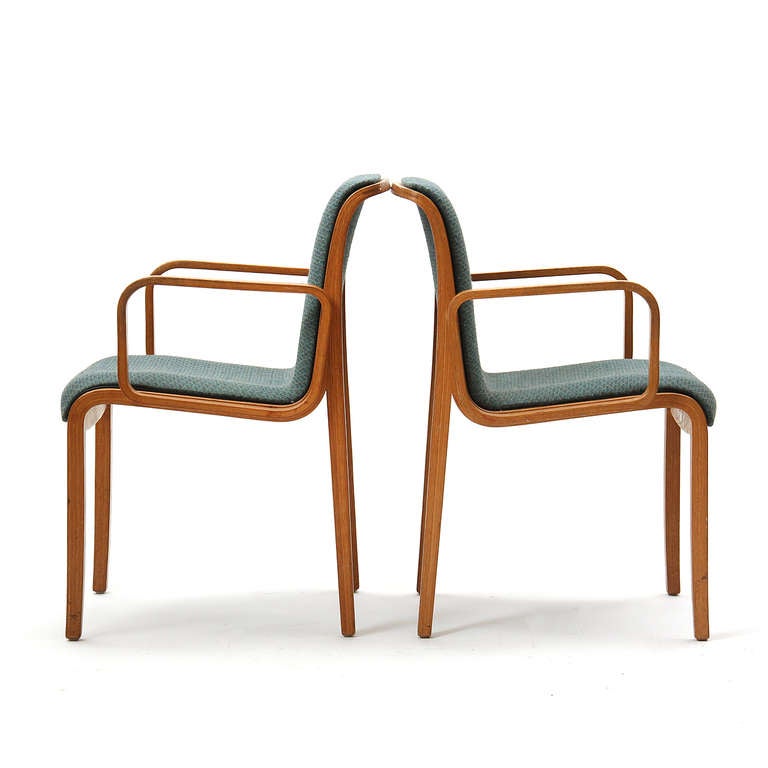 A pair of armchairs with bentwood laminated frames and arm rests.