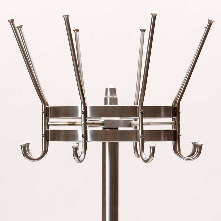 Stainless steel coat tree with rotating top on a stepped circular base.
