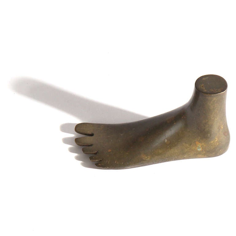 An expressive and wonderfully tactile paperweight in the form of a left foot made of warmly patinated brass.