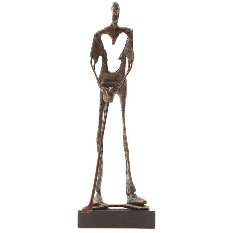 An unusual and unique bronze sculpture with dramatic use of negative space, in the form of a golfer, mounted on a dark rectangular base.