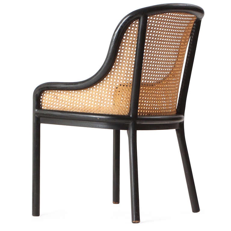 An elegant and comfortable armchair having a fluid and bold ebonized ash frame seamlessly encasing a woven cane seat and back.
