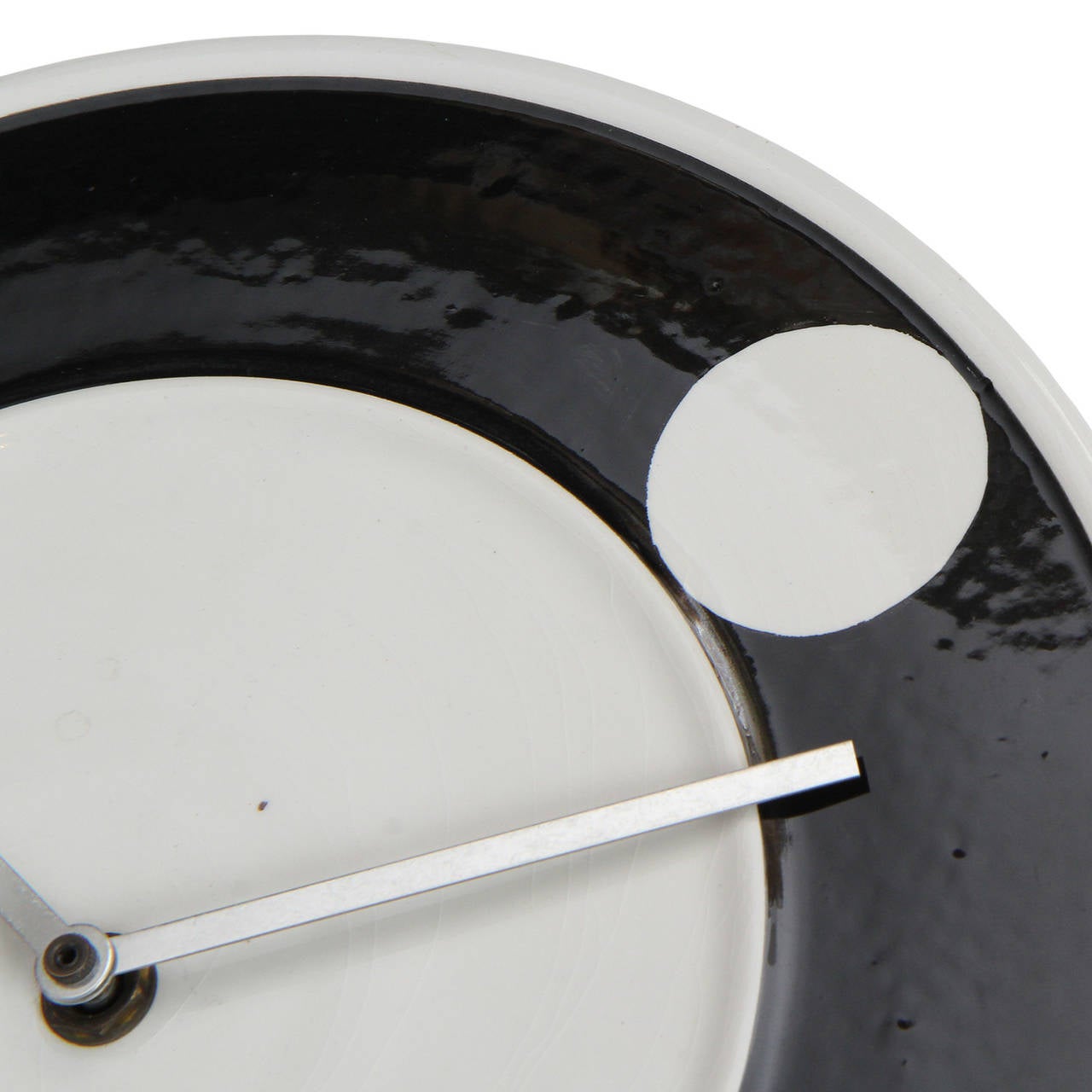 A beautifully graphic and elegant ceramic wall clock richly glazed in black and white having an abstracted face with the twelve o'clock marker defined by a white circle.