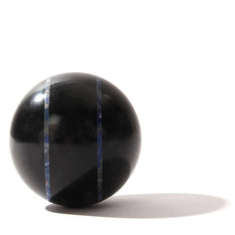 An absolute black marble ball with blue lapis bands.