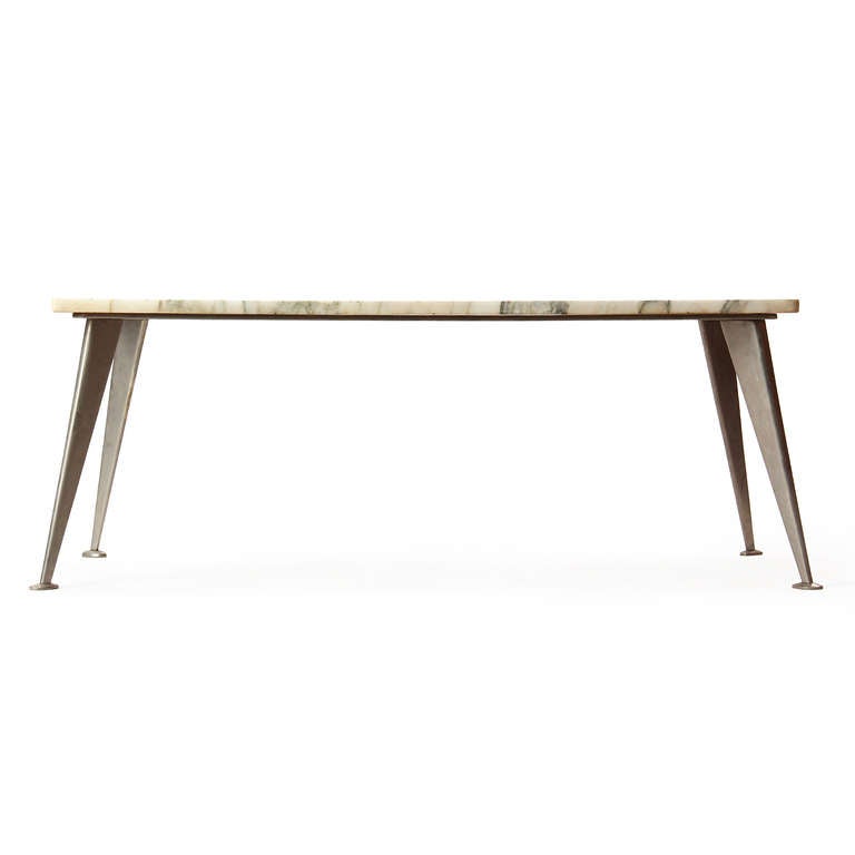 A nicely figured marble sits atop four tapered and splayed steel legs with an expressive 