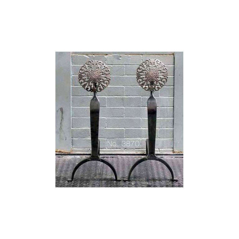 A pair of hand-worked Arts and Crafts andirons with patinated brass foliate finials and arched legs.

