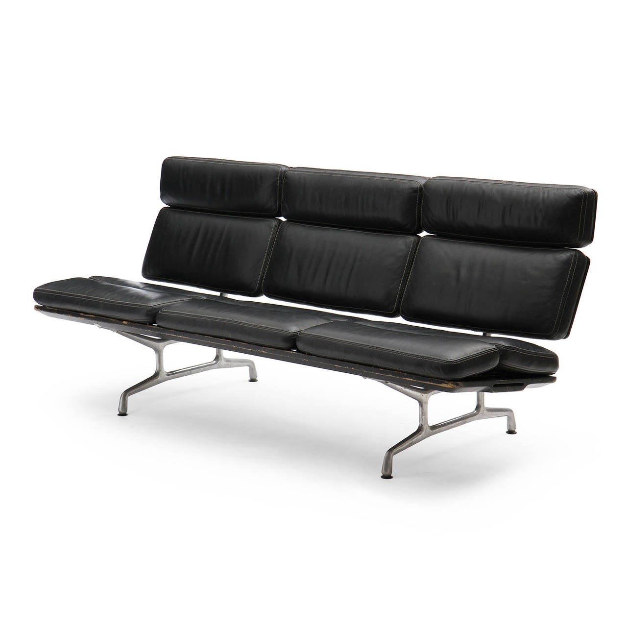 A modernist armless sofa with sectioned black leather upholstery and floating on sculptural polished cast aluminum legs. 