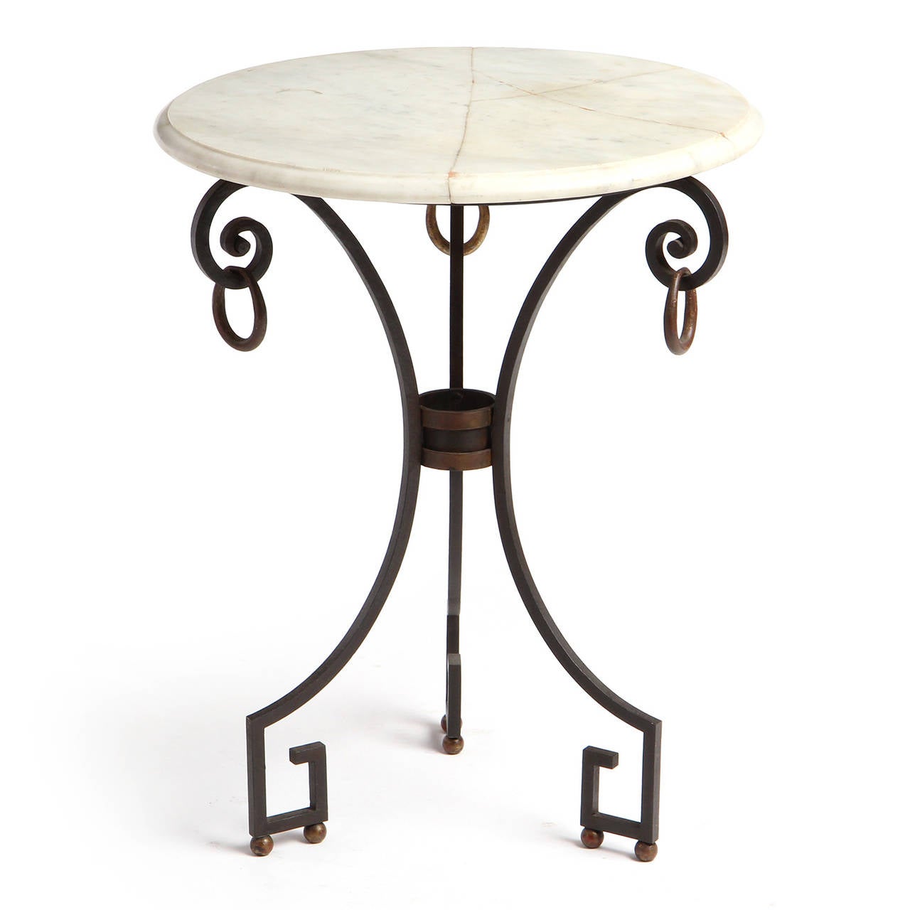 An occasional table having a wrought iron base with Greek Key feet and brass ball and ring embellishment supporting a round cream marble top with a beveled edge.