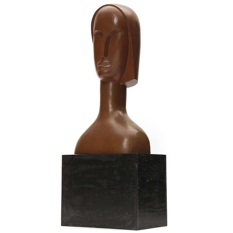 A modernist female bust elegantly carved from a single block of mahogany. Signed and dated.