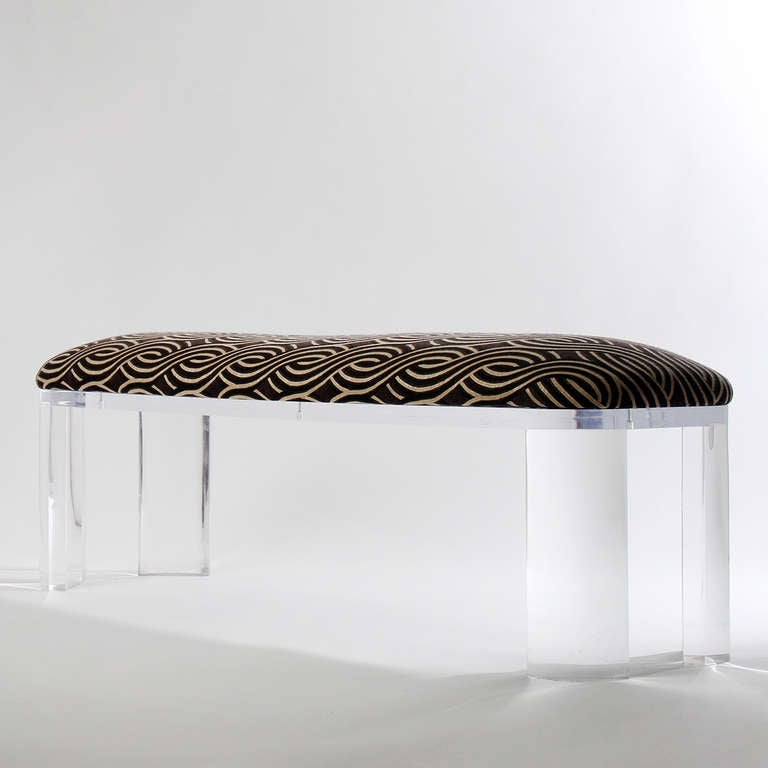 A wonderfully graphic bench having black and cream basketweave upholstery over an architectural lucite base.
