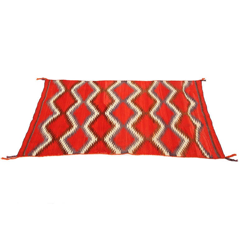 A superb and highly graphic Navajo weaving in fine original condition having a vivid palette of red, brown, cream and grey.