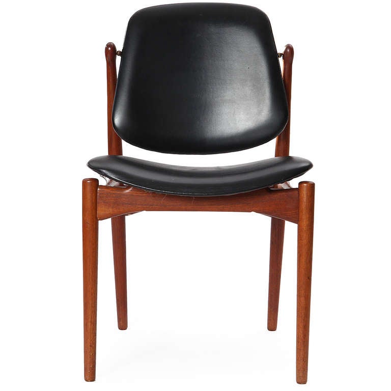 A fine set of dining chairs having exposed teak frames supporting leather wrapped molded seats and backs, the backs with a unique brass-hinged pivoting adjustment.