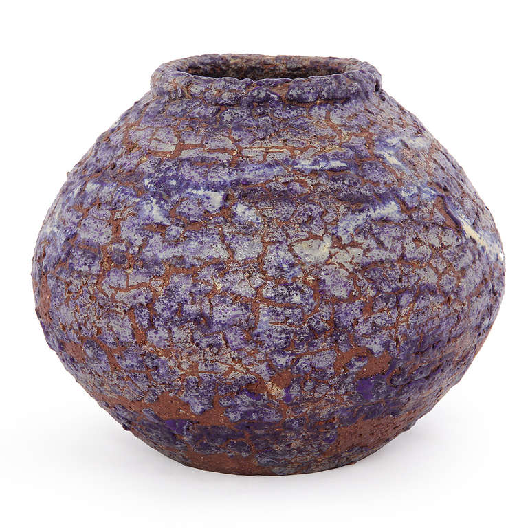 A hand-thrown ceramic vessel having an organic ovoid form and an unusual experimental persimmon-to-grey craquelure rustic glaze that is dramatically juxtaposed with the exposed natural clay body of the vase.