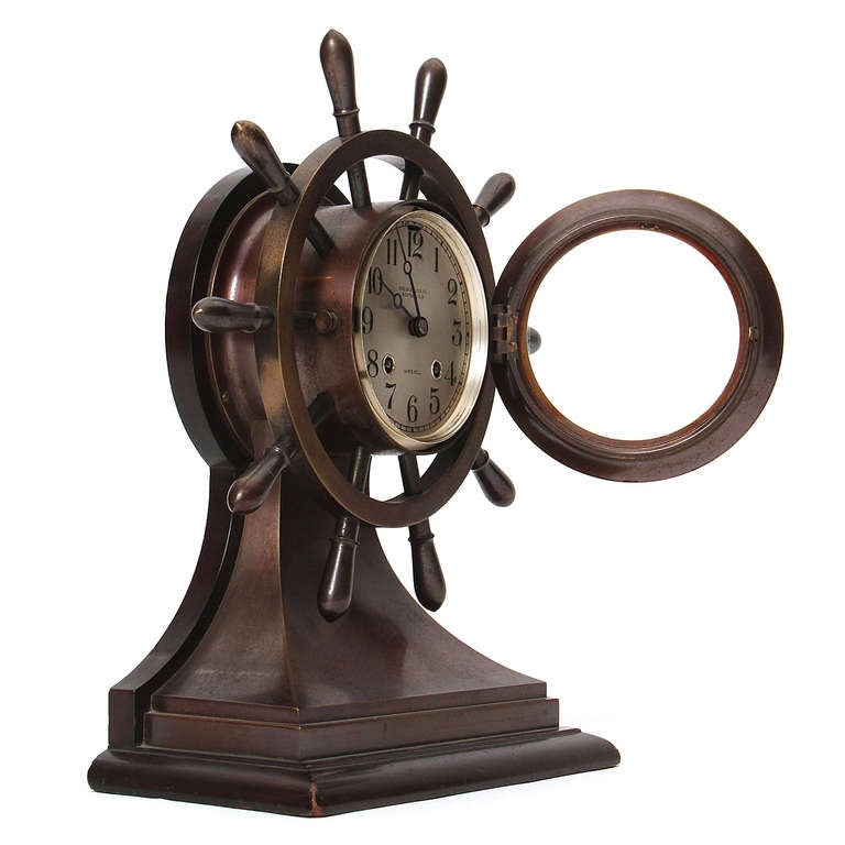 Une horloge en bronze finement ouvragée en forme de volant de yacht fabriquée par Chelsea Clock Company, Boston, Massachusetts, avec une lunette à charnière, un cadran argenté avec des chiffres arabes, une heure de huit jours et un mouvement à