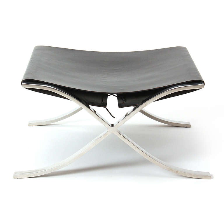 A low “Barcelona” stool with a chromed steel 