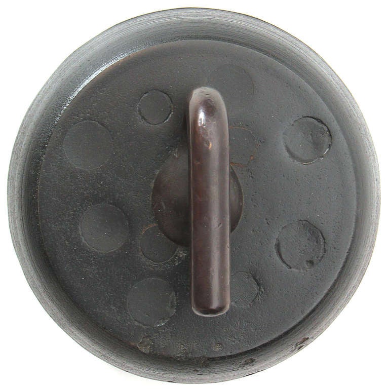 An unusual and finely patinated curling stone with a bronze handle and iron body.