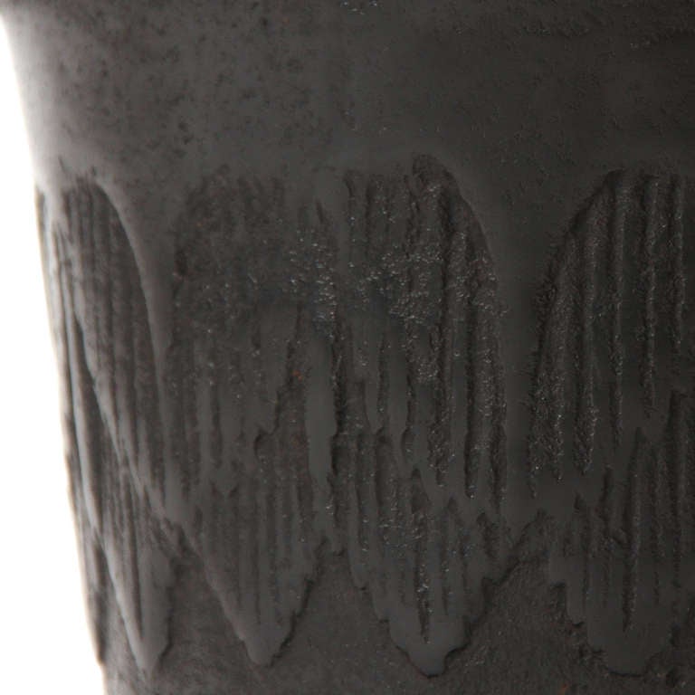A cast iron mortar with a bas-relief band in the center.