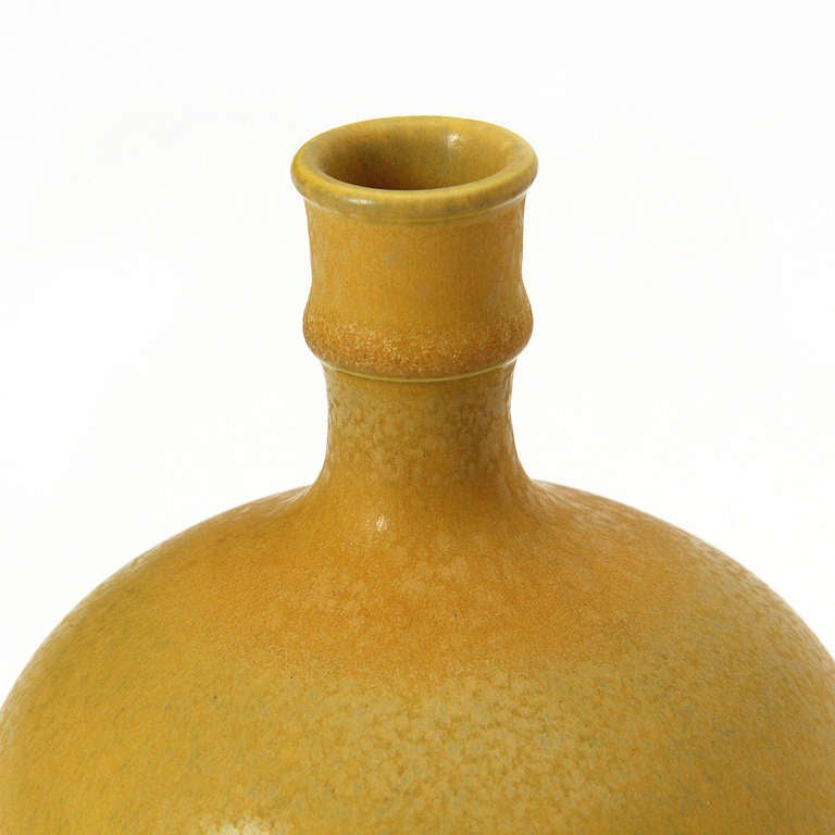A hand-thrown ceramic vase with a spherical body and a 