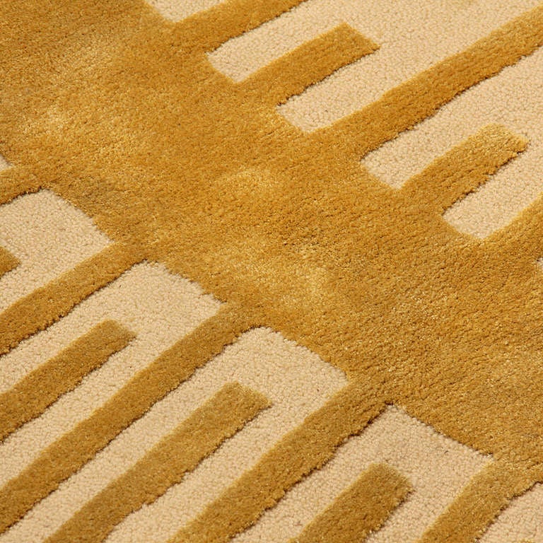 A large gold and yellow circular floor rug with a raised and  repeating sunburst pattern.