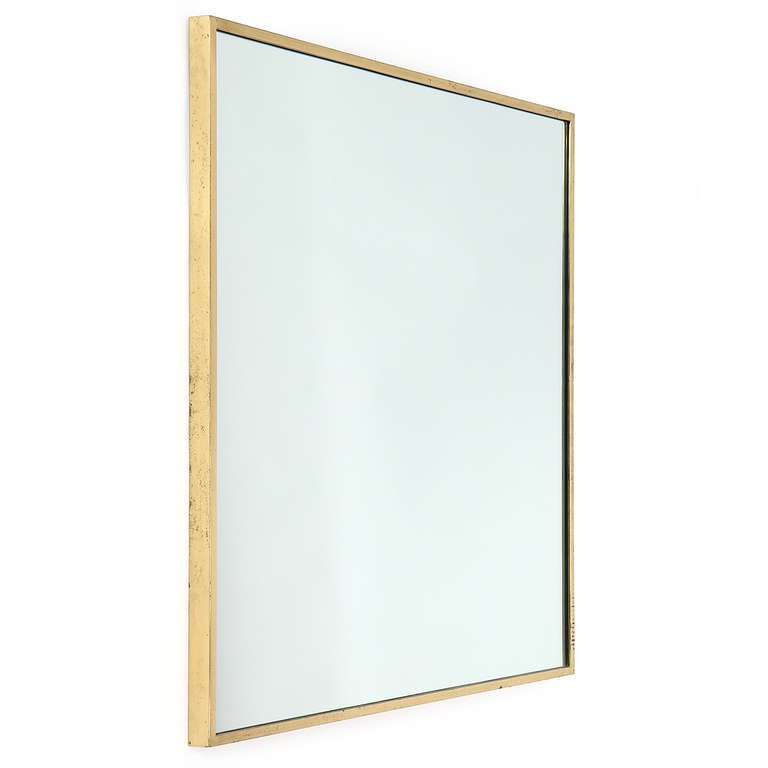 A rare and beautifully rendered thin-edged square mirror in warmly patinated brass.