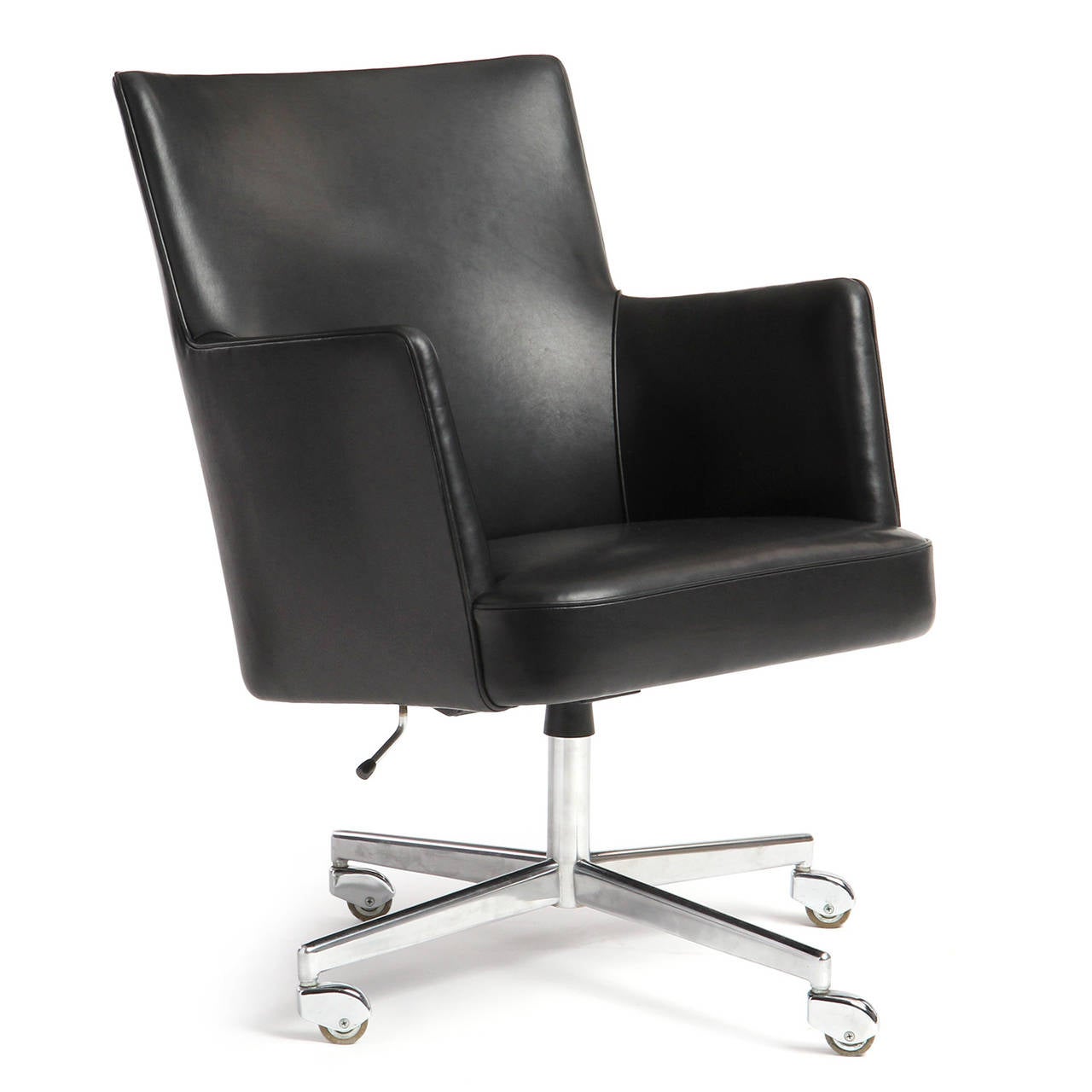 An uncommon swivelling and tilting generously proportioned desk chair having fitted black leather upholstery and a four-pronged brushed steel base on chrome-hooded casters.