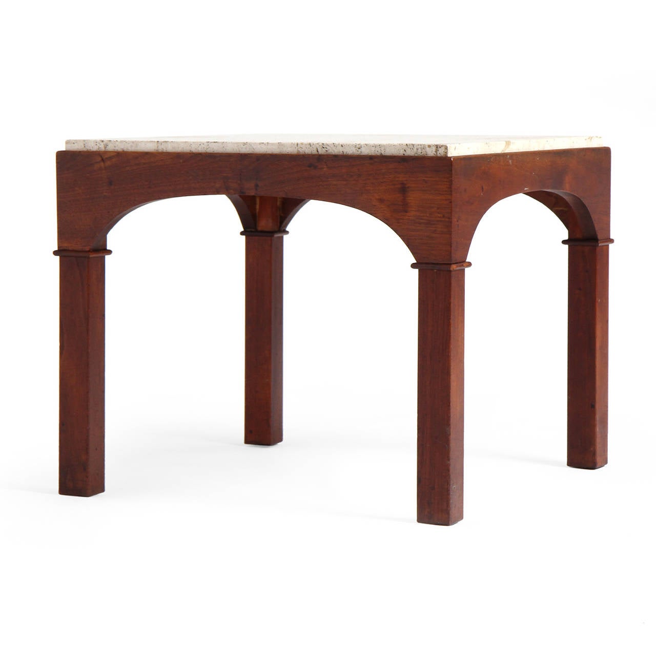 An expressive and elegantly detailed occasional table in walnut having arched aprons and inset travertine marble tops.