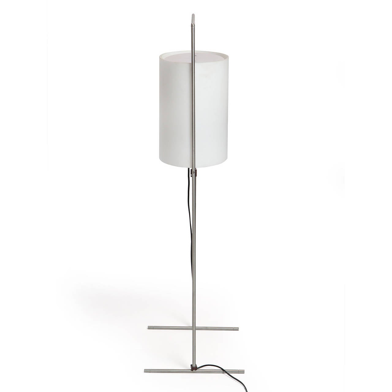 A floor lamp having a spare and linear brushed steel frame with sled feet supporting a suspended elliptical translucent glass shade.